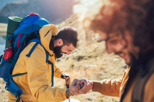 istock Helping hand - hiker man getting help on hike happy overcoming obstacle. 1066947530