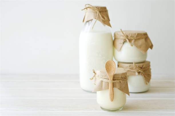 istock Dairy products in glass jars on light background 1066947822
