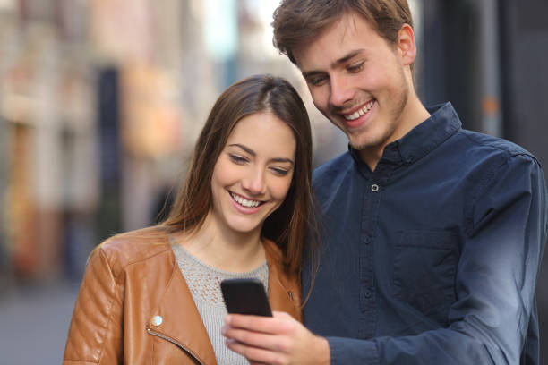 istock Happy mates watching smart phone content in the street 1066949842