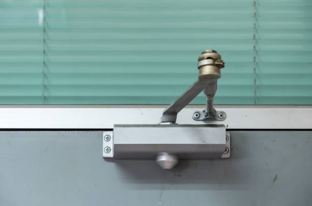 Old door closer. Old door closer is installing on the wooden door of the office meeting room. approaching stock pictures, royalty-free photos & images