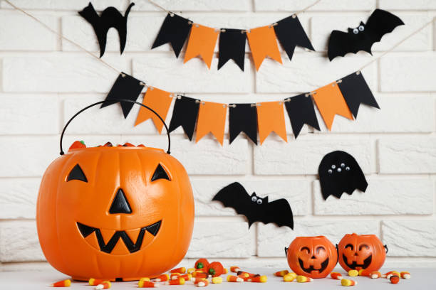 istock Halloween candy corns in pumpkin buckets on brick wall background 1066951590
