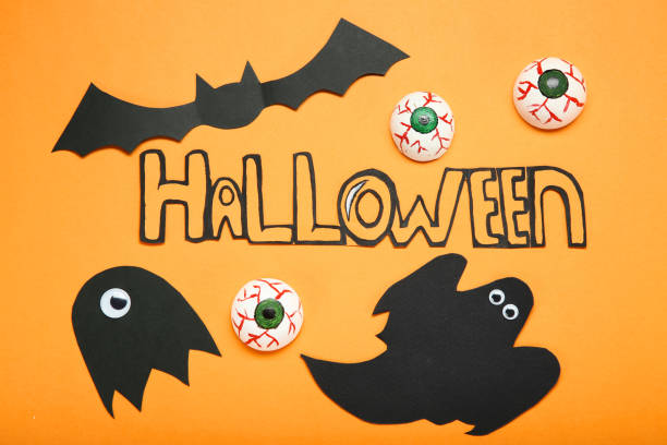 istock Paper halloween decorations on orange background 1066951684