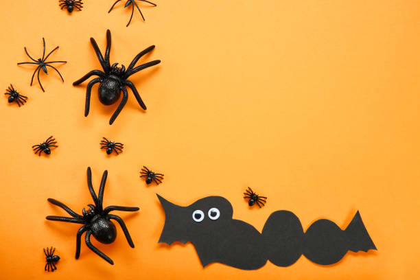 istock Halloween decorations with black spiders on orange background 1066951818