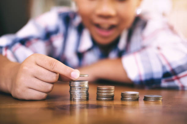 istock Saving money concept. Kid counting money and make coin stack. 1066954162