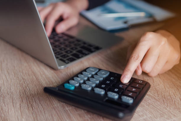 istock Business financial manager using calculator and laptop for analyzing finance graph data in office. successful concept. 1066954392