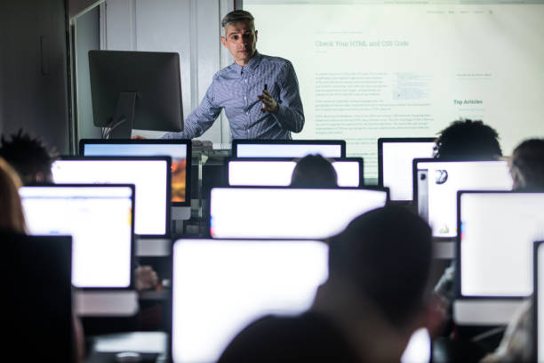 istock Mid adult teacher giving a lesson in computer lab. 1066956372