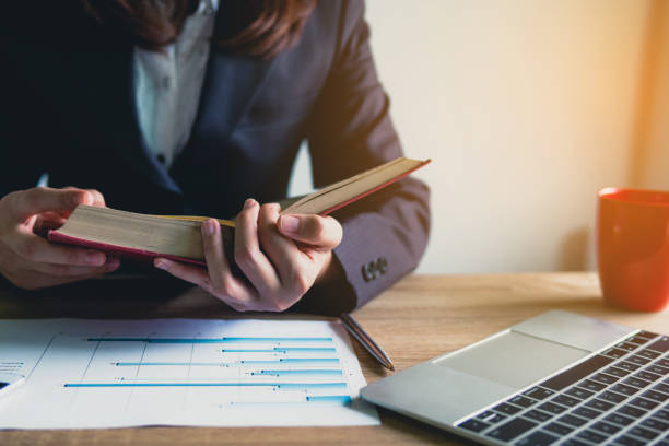 istock business women working with reading book at the office and Financial data analyzing counting on wood desk . 1066956462