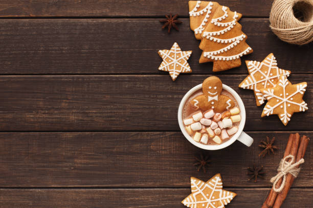 Gingerbread man bathing in cup of hot chocolate Cozy Christmas composition. Gingerbread man bathing in cup of hot cocoa with marshmallows, copy space, top view winter food top view stock pictures, royalty-free photos & images