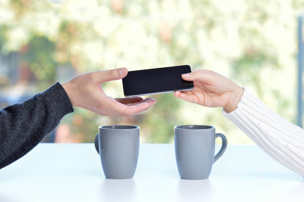woman with a phone in his hand return it to its owner at . Concept of loan from a phone to help someone in a bar or home interior