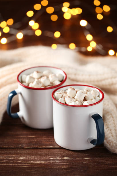 istock Cappuccino with marshmallows and knitted clothes on bokeh lights background 1066964400
