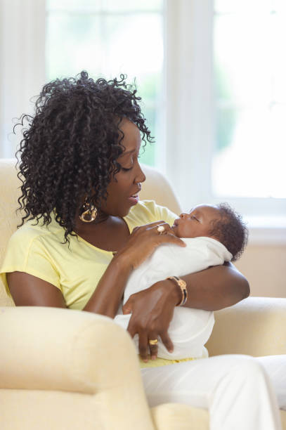 istock Smiling mom looks lovingly at her new baby 1066964730