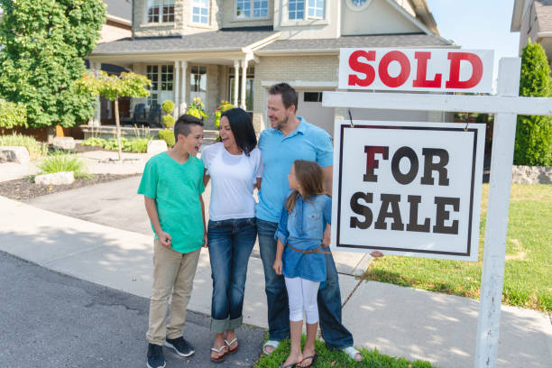 istock Family poses outside a recently sold house 1066965584