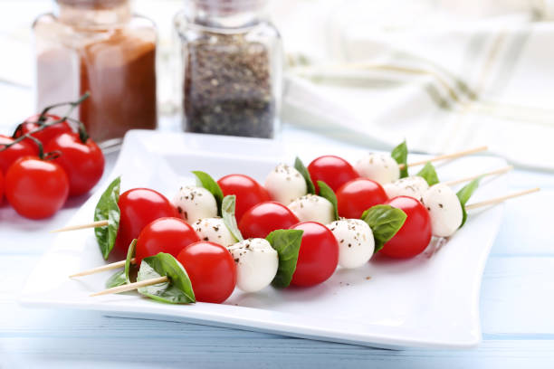istock Sticks with mozzarella, tomatoes and basil leafs on wooden table 1066970312