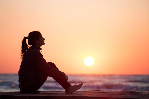 istock Lonely girl sitting on the sunrise beach 1066972876