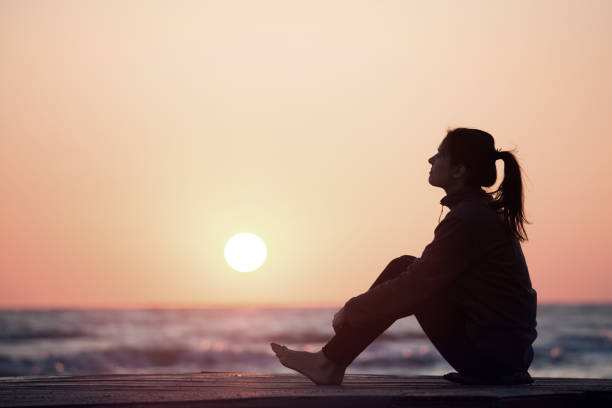 istock Lonely girl sitting on the sunrise beach 1066972992