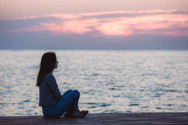 istock Lonely girl sitting on the sunrise beach 1066973036