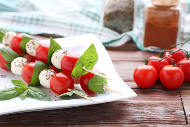 istock Sticks with mozzarella, tomatoes and basil leafs on brown wooden table 1066973322