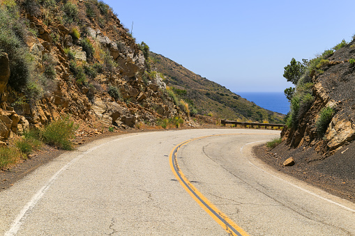 The curvy Mulholland Highway near Malibu with the blue shimmering Pacific Ocean on the horizon.