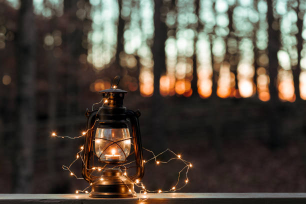 istock Old style lantern with lights over woodland background 1066976608