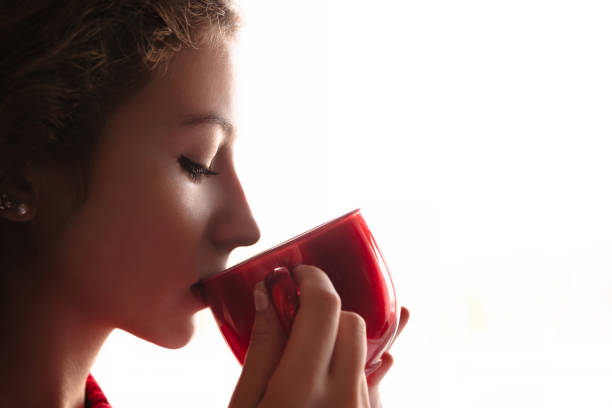 istock Beautiful girl drinking tea or coffee from red cup 1066976892