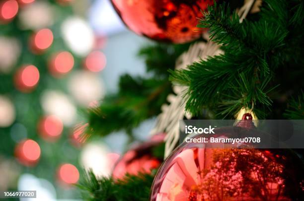 Red Bauble And Other Ornament Hanging On Christmas Tree With Bokeh Background From Another Christmas Tree With Space For Text Stock Photo - Download Image Now