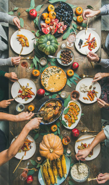istock Friends feasting at Thanksgiving Day table with turkey, vertical composition 1066977830