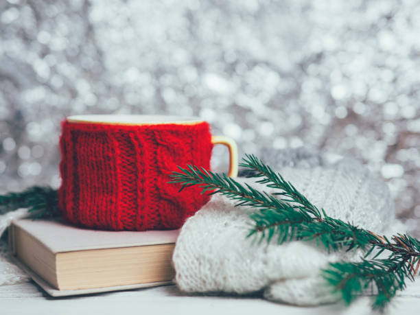istock A mug with a winter drink and a book on a white wooden table 1066981988