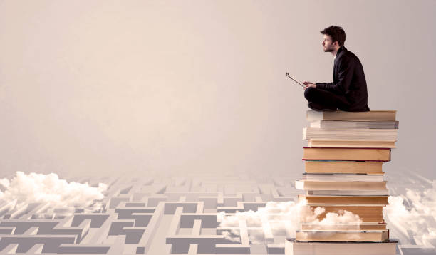 istock Man with tablet sitting on books 1066982538