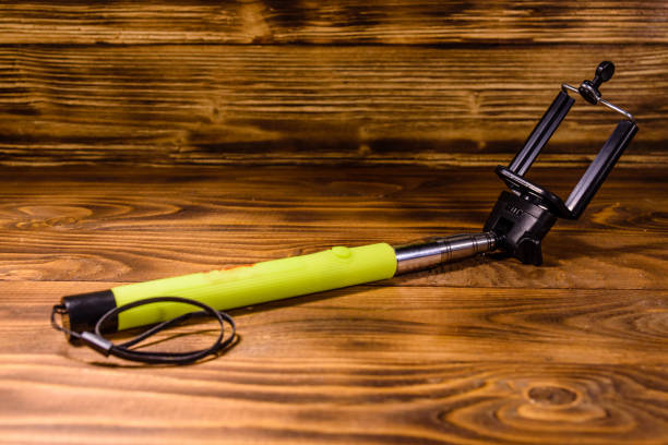 istock Selfie stick with adjustable clamp on a wooden table 1066986226
