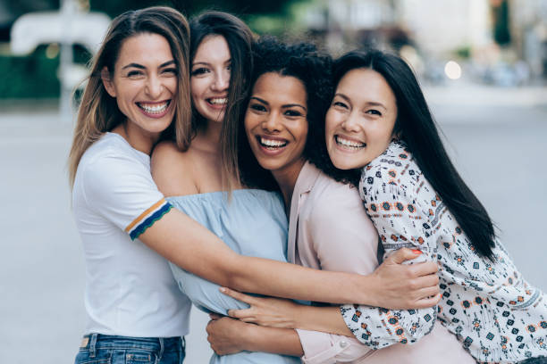 Group of international girlfriends Group of international girlfriends hug each other outdoors cheek to cheek photos stock pictures, royalty-free photos & images