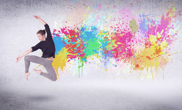 istock Modern street dancer jumping with colorful paint splashes 1066990286
