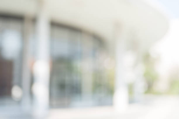 istock Office or university building blur background exterior view with blurry empty lobby space, entrance hall glass wall window and light bokeh 1066991892