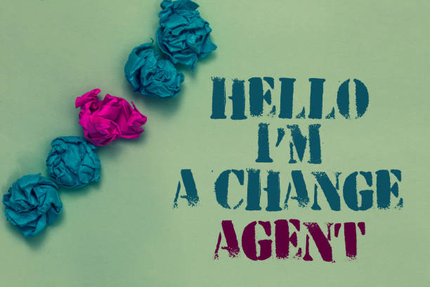 istock Writing note showing Hello I am A Change Agent. Business photo showcasing Promoting and enabling difference evolution new Drawn blue and red words teal color paper lump mid pink on blue floor. 1066995202