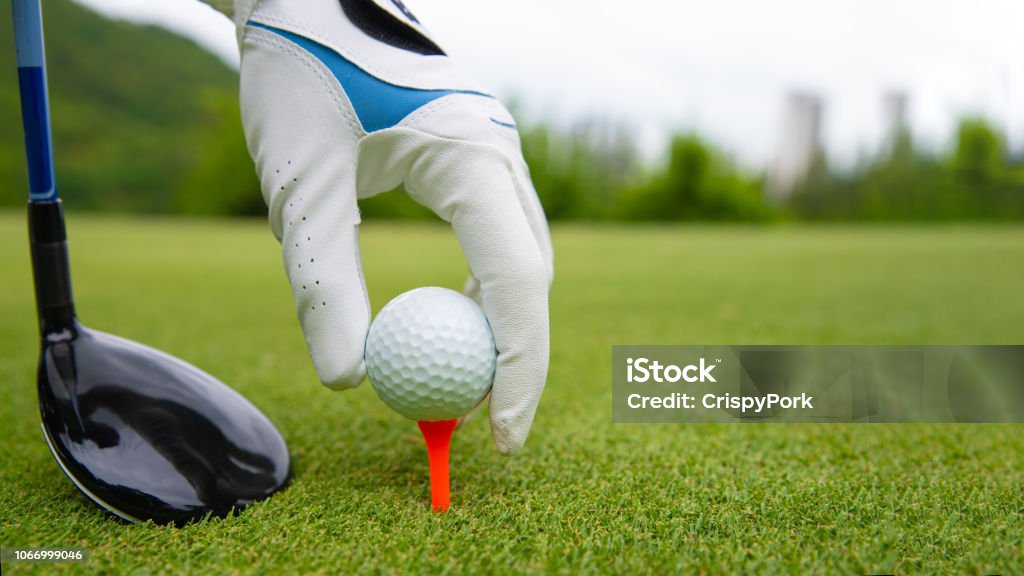 Mano poniendo pelota de golf en Tee en el campo de golf - Foto de stock de Golf libre de derechos