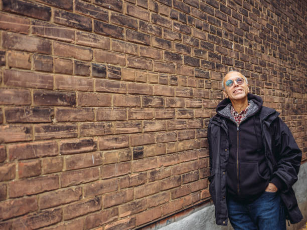 istock Senior man in front of brick wall 1066999052