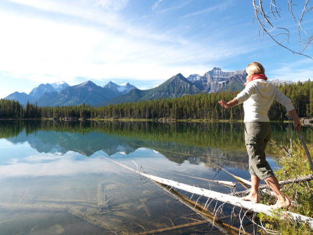 istock Female hiker balances on log, in mountains 1066999068