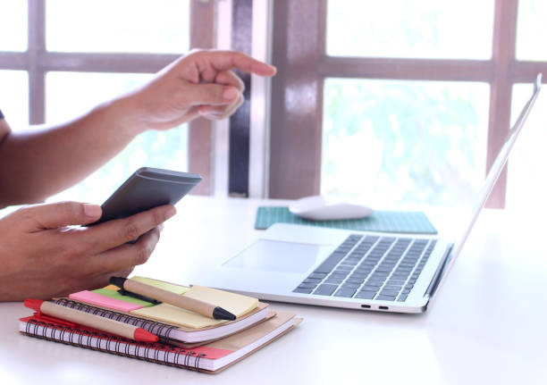 istock side view,business man holding smartphone and point.office table desk. workspace with notebook and mouse on copy space 1067000076