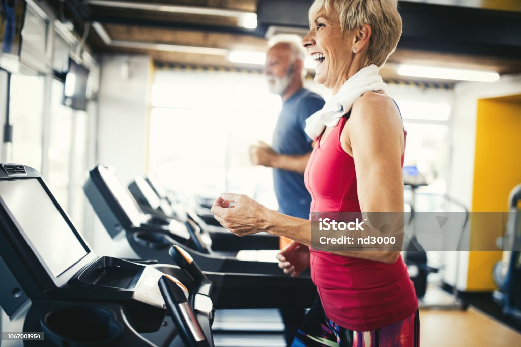 Senior people running in machine treadmill at fitness gym club Mature people running in machine treadmill at fitness gym club Senior Adult Stock Photo