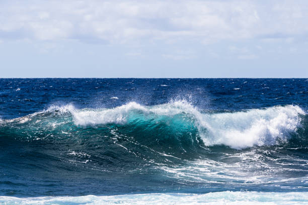 istock Blue-green wave breaking on Hawaii's Big Island. Foam on top; deep blue Pacific ocean in background. 1067003498