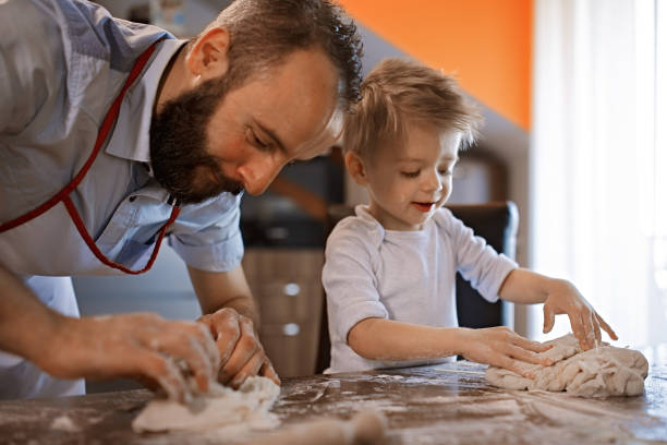 istock Cute little baker and his father making a bread 1067004902
