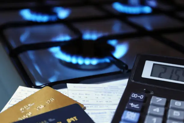 Photo of bank cards and a calculator on the background of a gas stove