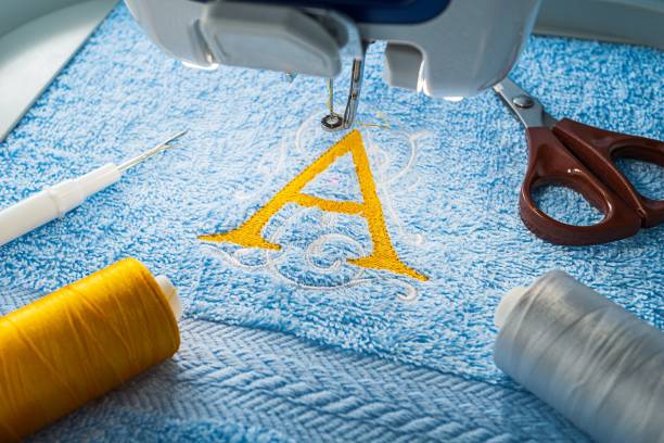 embroidery machine and alphabet design on towel - sewing foot imagens e fotografias de stock