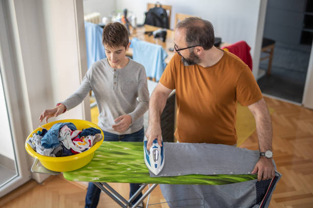 istock Father and son ironing together 1067008834
