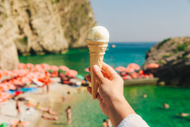 istock woman hand hold ice cream sea on background 1067014568