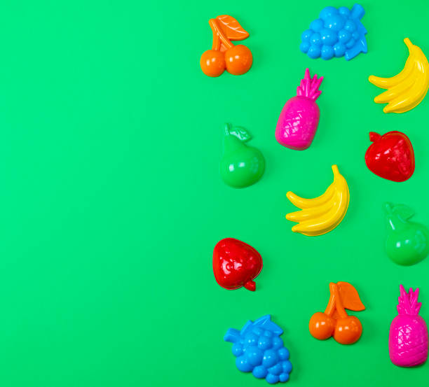 istock multicolored plastic toys fruits on a green background 1067016178