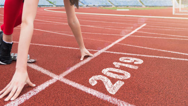 istock Athlete starting line on running track with 2019 year 1067019784
