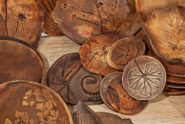 istock Clay pottery and ceramic products on a wooden table. Home workshop. Handmade with drawings and patterns. 1067020872