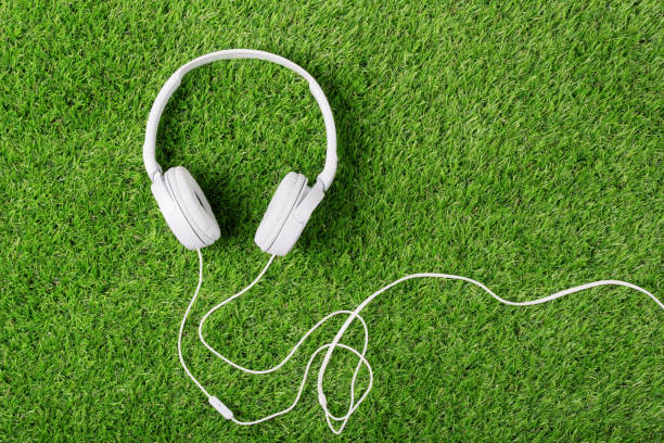 istock White headphones on a green grass 1067021506