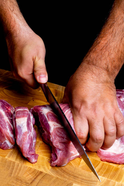 istock professional man's hands cutting raw pork meat, selective focus, close-up 1067022514
