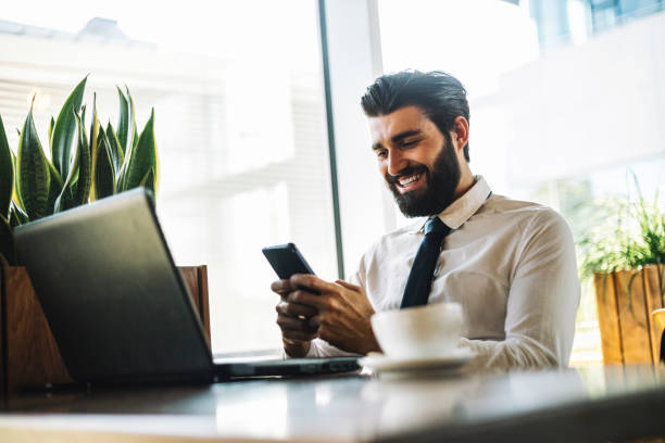 istock Attractive young businessman drinks coffee and using smart phone 1067025066